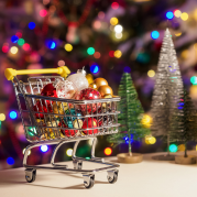 Natal 2023: imagem de carrinho de compras cheio de bolas de natal e uma árvore de natal ao fundo
