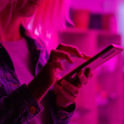 uso de apps: imagem de mulher usando o celular com filtro rosa aplicado