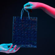Shopper e consumidor: fundo preto com duas mãos, uma dando e outra recebendo uma sacola brilhante