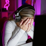 millennials: mulher em frente ao computador com as mãos cobrindo o rosto preocupada